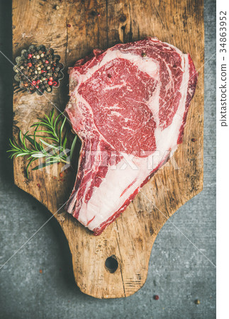 Raw uncooked beef steak rib-eye on board, top view Raw uncooked beef steak rib-eye on board, top view 34863952