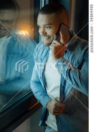 Confident mulatto touching his shirt 34864490