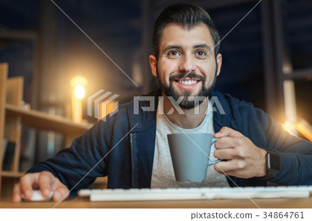 Positive delighted male enjoying his work Positive delighted male enjoying his work 34864761