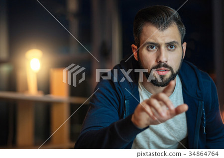 Concentrated bearded man pointing at computer Concentrated bearded man pointing at computer 34864764