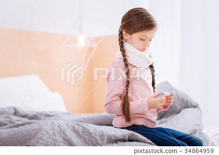 Attentive child sitting on the bed with a Attentive child sitting on the bed with a 34864959