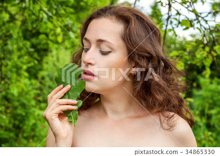 Girl with the leaf in her hand in a park 34865330