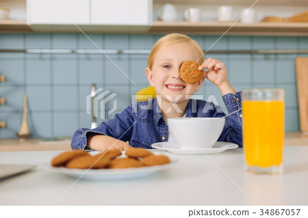 Joyful nice girl playing with a cookie Joyful nice girl playing with a cookie 34867057