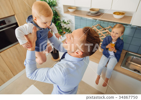 Happy nice man playing with his baby daughter 34867750