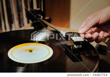 Female hand dropping a needle on a record Female hand dropping a needle on a record 34867754