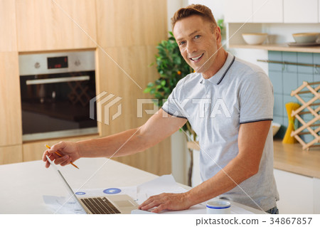 Cheerful positive man opening his laptop 34867857