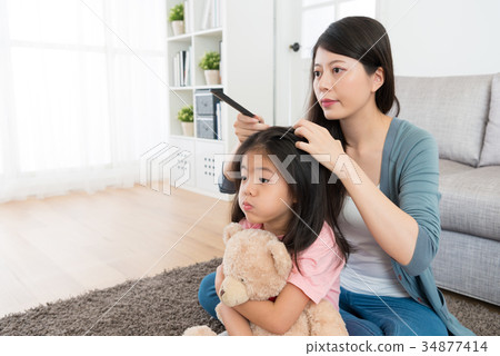 little girl holding teddy toy sitting on floor little girl holding teddy toy sitting on floor 34877414