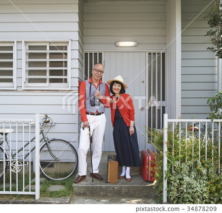Senior couple travel departure front door 34878209