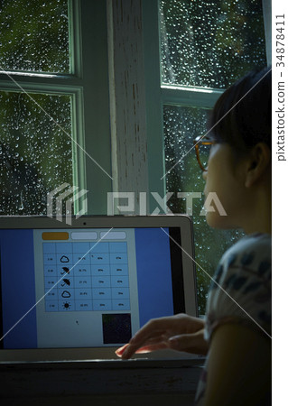 Rainy day woman searching for weather forecast Rainy day woman searching for weather forecast 34878411