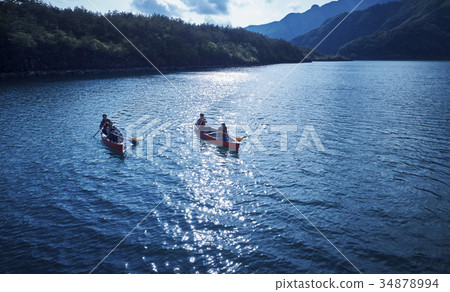 Family rowing a canoe 34878994