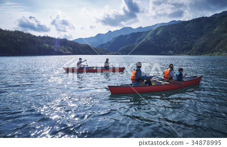 Family rowing a canoe 34878995