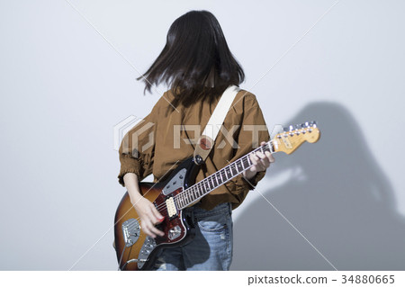 A woman playing the guitar A woman playing the guitar 34880665