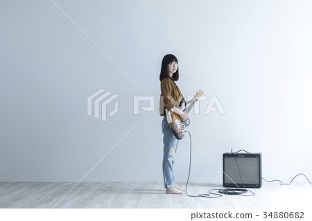 A woman playing the guitar 34880682