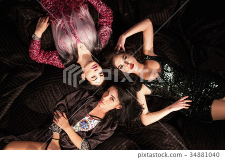 Sexy girls posing for camera lying on softbags Sexy girls posing for camera lying on softbags 34881040