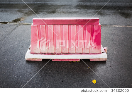 Red plastic road barrier stands on the street 34882000