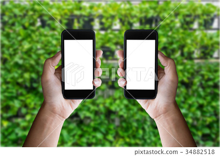 Man holding blank screen of a smartphone at the green garden Man holding blank screen of a smartphone at the green garden 34882518