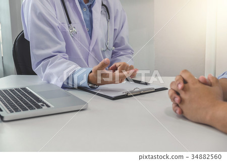 Close up of doctor filling up an history form while consulting p 34882560