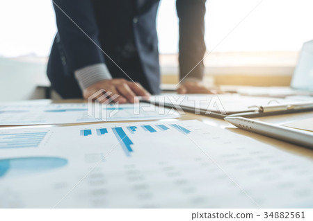 business man working and pointing to graph document finance proj 34882561