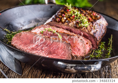 Juicy medium beef Rib Eye steak slices in pan. 34883314