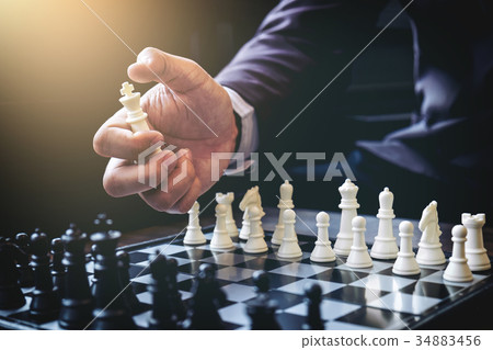 Close up of hands confident businessman colleagues playing chess 34883456