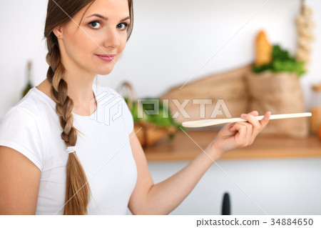 Young woman is cooking in a kitchen. Housewife is 34884650