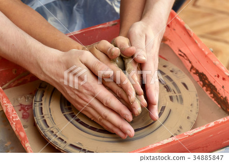 Hands of two people create pot, potter's wheel 34885847
