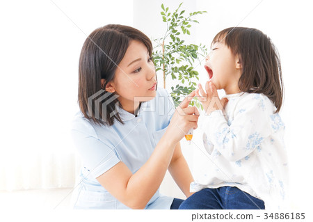 Child receiving dental treatment 34886185