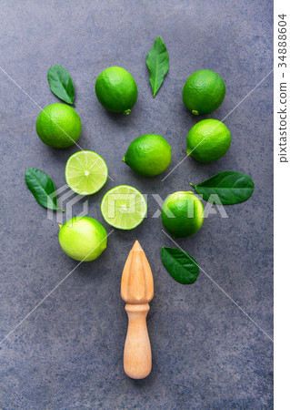 Fresh limes and wooden juicer on  background.  34888604