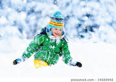 Child playing with snow in winter. Kids outdoors. Child playing with snow in winter. Kids outdoors. 34889948