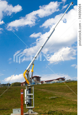 Snow cannon close up against blue sky white clouds Snow cannon close up against blue sky white clouds 34890064