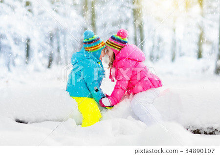 Kids playing in snow. Children play in snowfall. Kids playing in snow. Children play in snowfall. 34890107