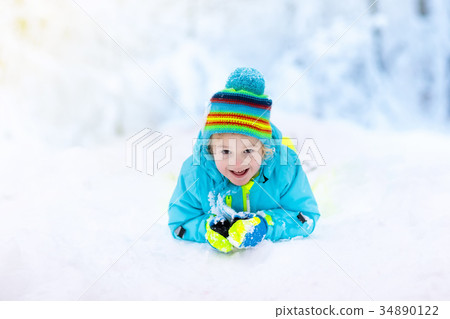 Child playing with snow in winter. Kids outdoors. Child playing with snow in winter. Kids outdoors. 34890122