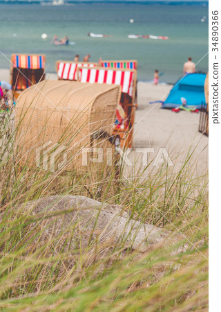Roofed wooden chairs on sandy beach in Travemunde 34890366