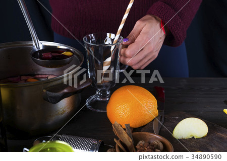 female hands pouring hot mulled wine 34890590