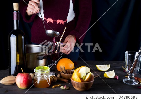 female hands pouring hot mulled wine female hands pouring hot mulled wine 34890595