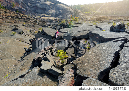 Young female tourist exploring surface of the Kilauea Iki volcano crater Young female tourist exploring surface of the Kilauea Iki volcano crater 34893718