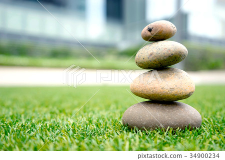 stones stacked up on grass stones stacked up on grass 34900234