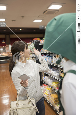Woman asking for product location at supermarket Woman asking for product location at supermarket 34901722