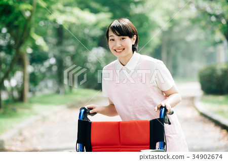 Wheelchair and young carer helper woman 34902674