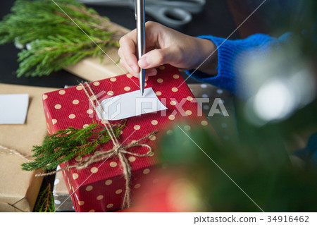 Write Christmas greetings in a card 34916462