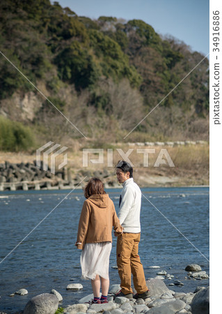 一對年輕夫婦的背面圖在河岸的 34916886