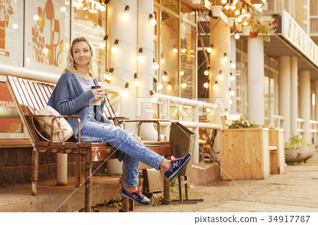 Cheerful woman in the street drinking morning Cheerful woman in the street drinking morning 34917787