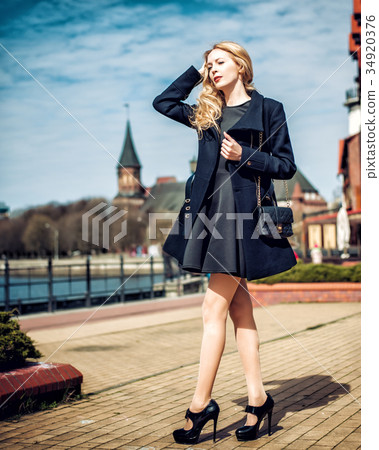 Fashion girl wearing coat, handbag and black dressin city Fashion girl wearing coat, handbag and black dressin city 34920376