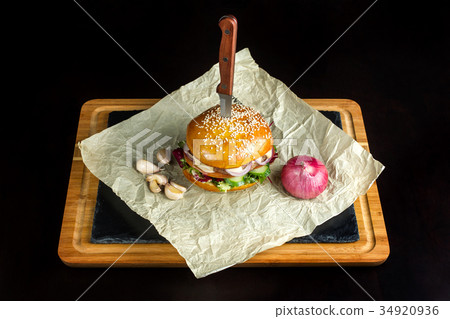 Hamburger with garlic is on kraft paper. Hamburger with garlic is on kraft paper. 34920936