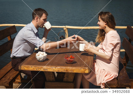 happy couple drinking tea outdoors happy couple drinking tea outdoors 34932088