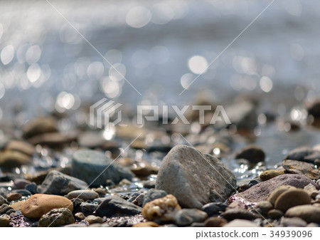 The surface of the river shines beautifully in the bright light of spring with silver, purple, and green bokeh. 34939096