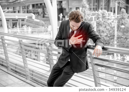 Businessmen is having a heart attack and holding hand on the che 34939124