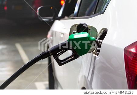 Fuel nozzles adding gasoline fuel in car  34948125
