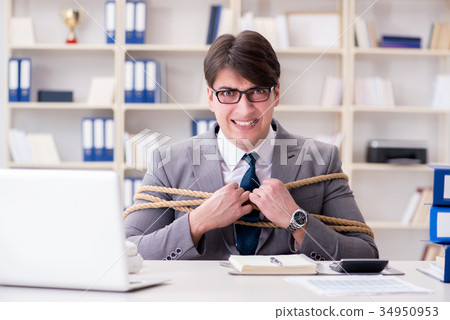 Businessman tied up with rope in office 34950953