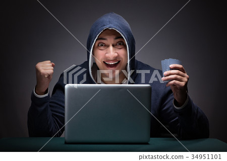 Young man wearing a hoodie sitting in front of a Young man wearing a hoodie sitting in front of a 34951101